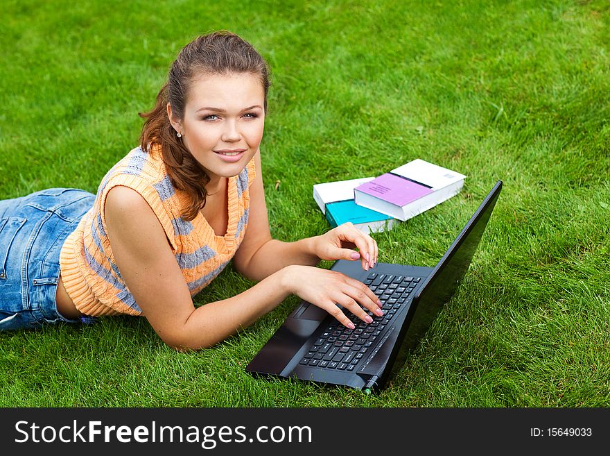 Pretty teenage girl styding on fresh air with laptop and books looking at camera. Pretty teenage girl styding on fresh air with laptop and books looking at camera