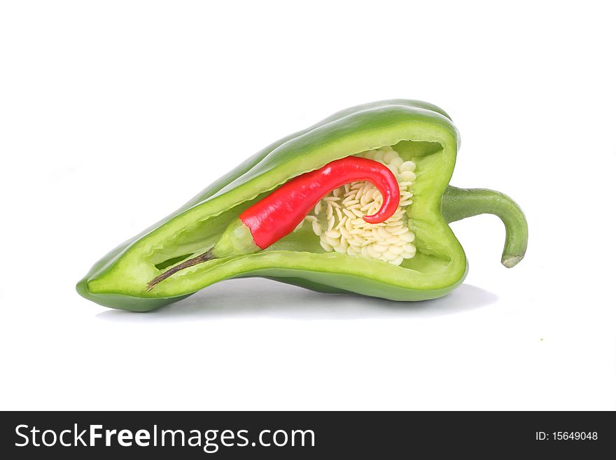 Red chili pepper inside sliced green pepper isolated on white. Red chili pepper inside sliced green pepper isolated on white