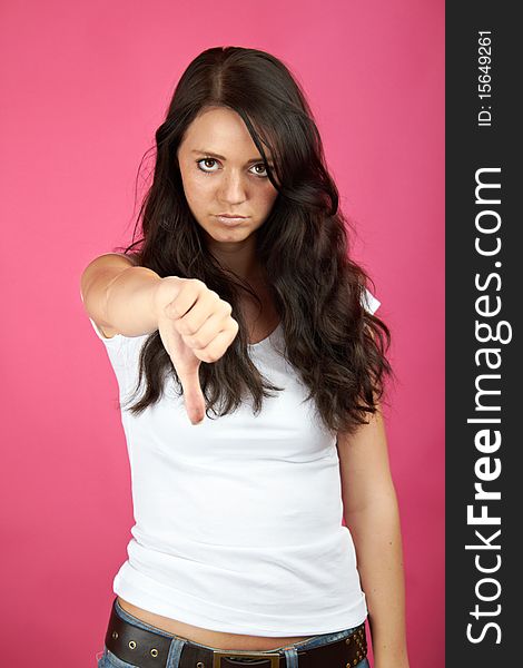 Portrait of a young angry woman with thumb down. Portrait of a young angry woman with thumb down