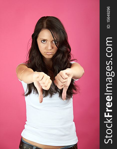 Portrait of a young angry woman with thumb down. Portrait of a young angry woman with thumb down