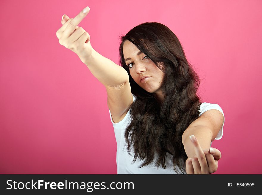 Portrait of a young angry woman is showing her middle-finger. Portrait of a young angry woman is showing her middle-finger