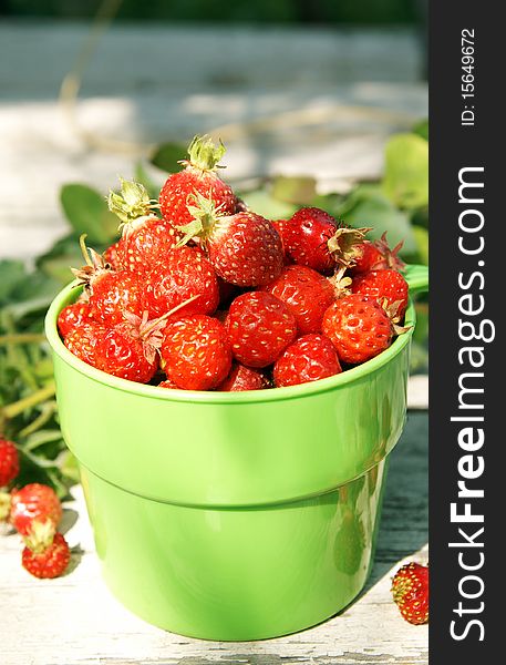 Ripe juicy strawberries in a green cup