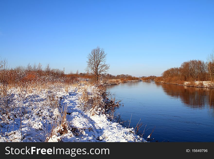 Winter snow on field near river