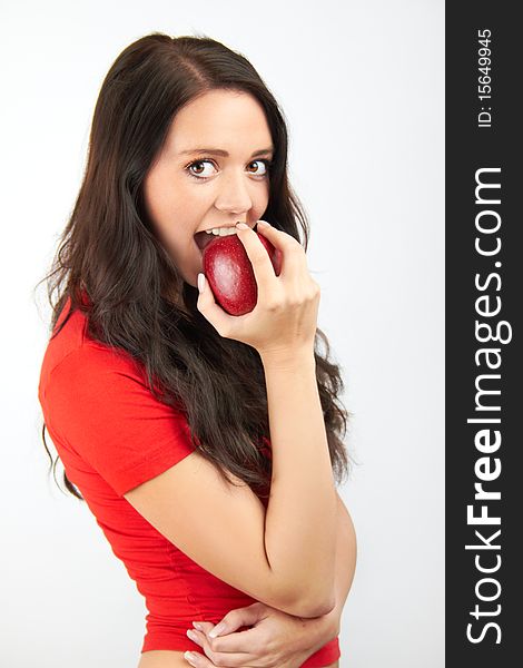 A healthy beautiful happy woman is eating an red apple. A healthy beautiful happy woman is eating an red apple