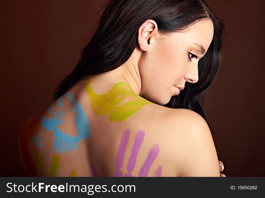 The back of a young woman with bodypainting hands. The back of a young woman with bodypainting hands