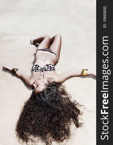 Young beautiful woman sunbathing on the sand