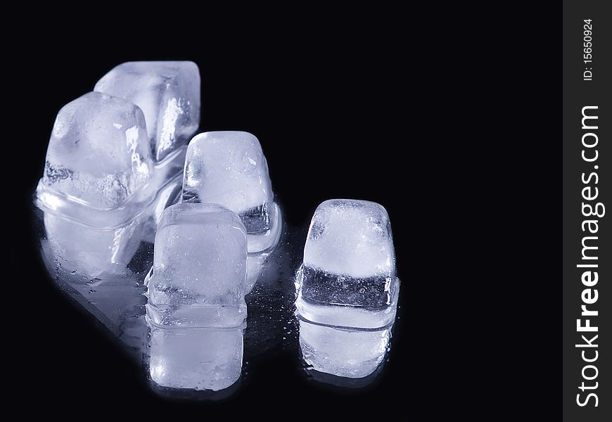 Some ice cubes over reflective black background