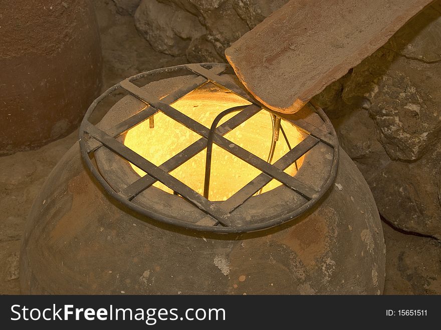 Clay jug with a fence on it and fire inside