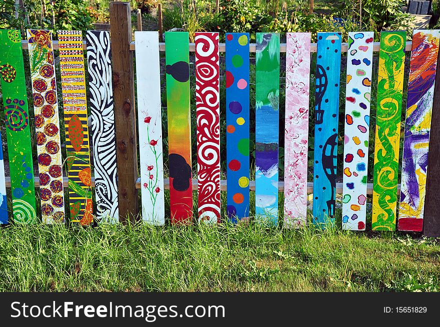 Colorful painted wooden fence in garden. Colorful painted wooden fence in garden