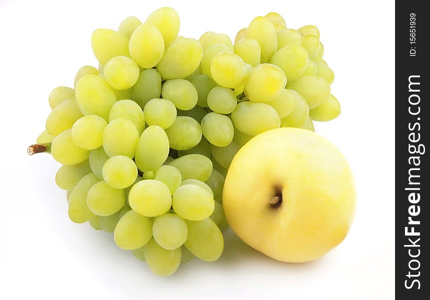 Ripe grapes and yellow apple on a white background. Ripe grapes and yellow apple on a white background