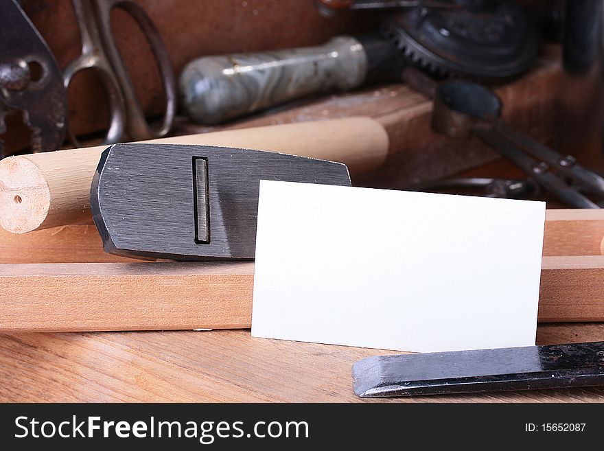 Metalwork workshop with old tools and business card.