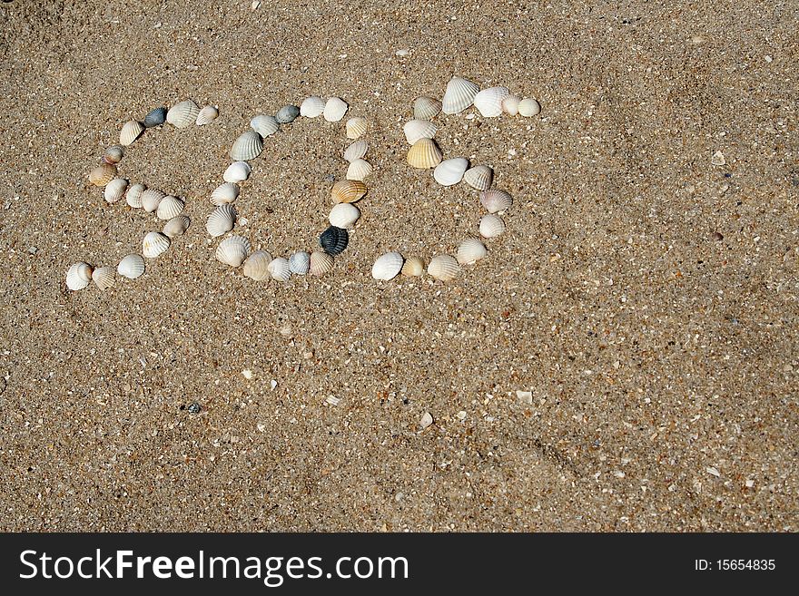 The distress signal combined from sea cockleshells on sandy coast. The distress signal combined from sea cockleshells on sandy coast