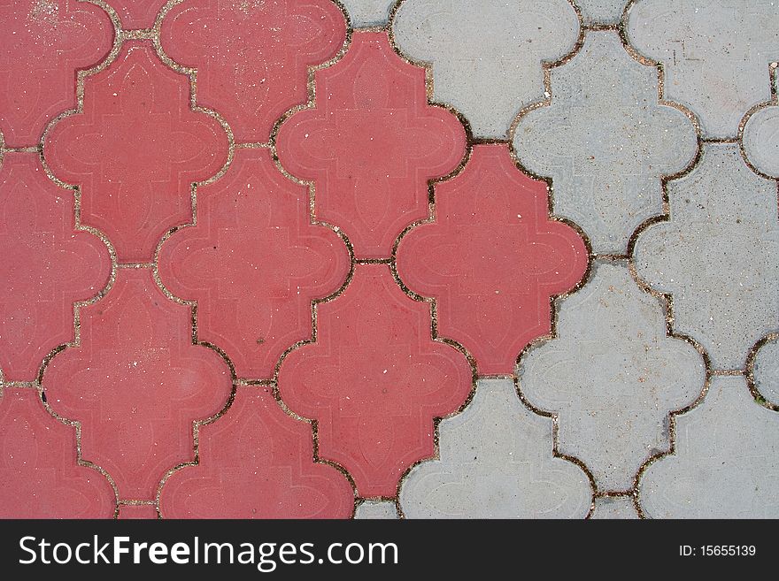 Pedestrian trail paved with red and gray stone tiles. Texture, background. Pedestrian trail paved with red and gray stone tiles. Texture, background