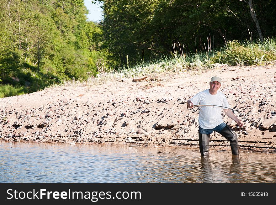 Senior fisherman fishing on a river. Senior fisherman fishing on a river