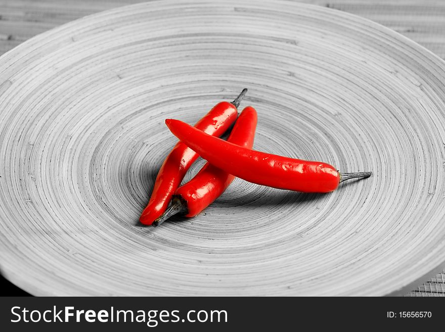Shot of red peppers on a round wooden plate. Shot of red peppers on a round wooden plate.