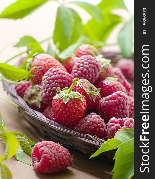 Fresh, ripe raspberries and strawberries in little wooden berry baskets. Fresh, ripe raspberries and strawberries in little wooden berry baskets.