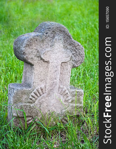 Ancient stone Christian cross on a green grass background. Ancient stone Christian cross on a green grass background