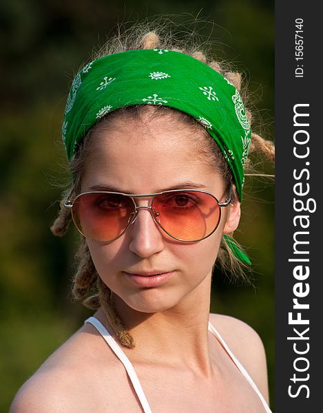 Young hippie woman  in a green  headscarf and sunglasses. Young hippie woman  in a green  headscarf and sunglasses