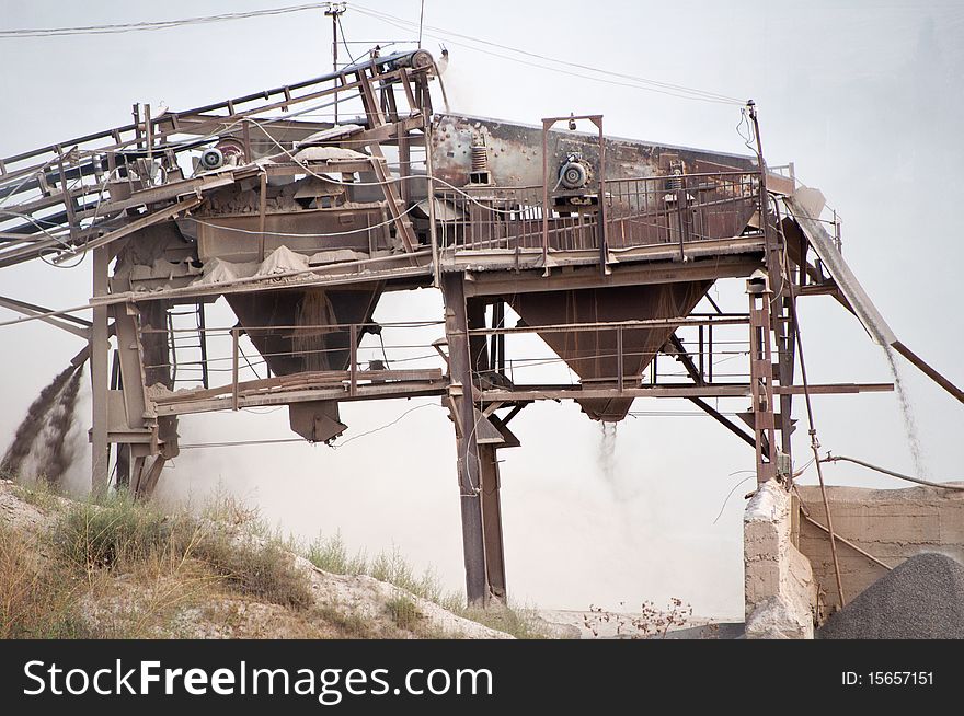 Old, dirty, grey, dusty gravel crusher  machine