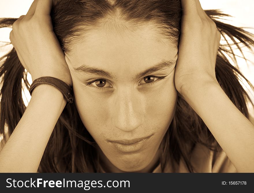 Monochrome portrait of a attractive teenager with shaggy hair, head in hands.