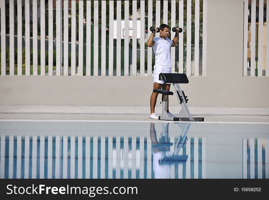 Young healthy athlete man exercise at poolside