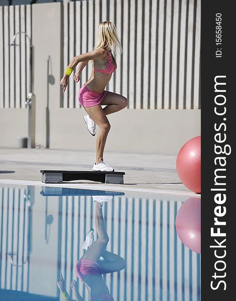 Young beautiful healthy woman exercise fitness and stepping at swimming pool. Young beautiful healthy woman exercise fitness and stepping at swimming pool
