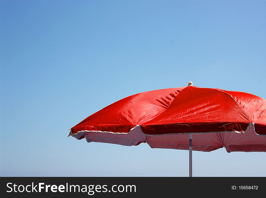 Beach umbrella on the blue sky background