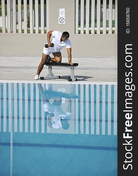 Young healthy athlete man exercise at poolside. Young healthy athlete man exercise at poolside