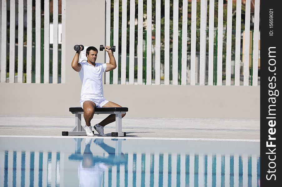 Young healthy athlete man exercise at poolside. Young healthy athlete man exercise at poolside