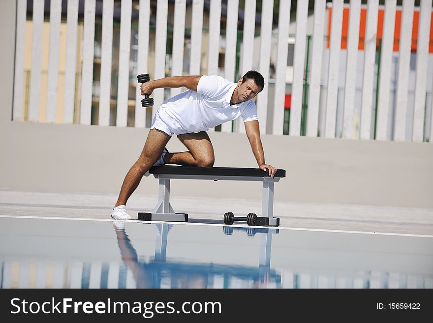 Young healthy athlete man exercise at poolside. Young healthy athlete man exercise at poolside