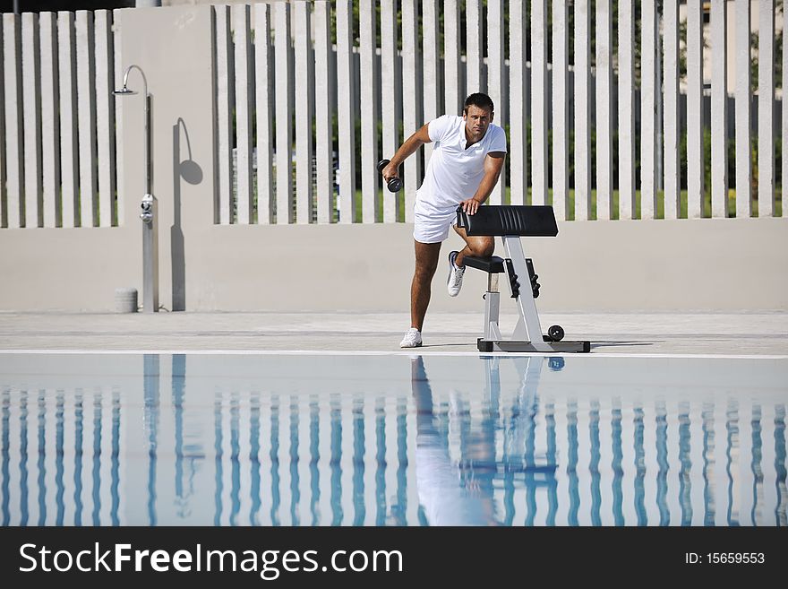 Young healthy athlete man exercise at poolside. Young healthy athlete man exercise at poolside