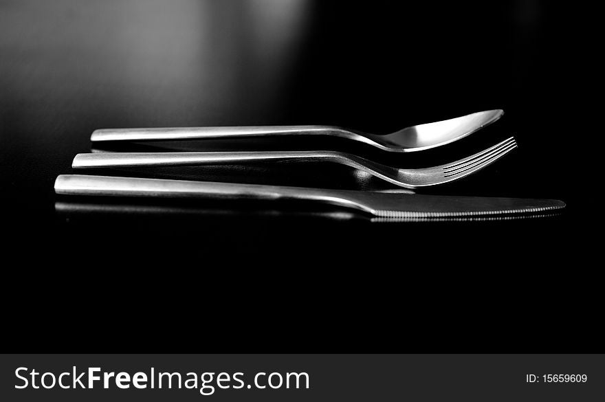 Silverware on black table (shallow DOF, focus on fork)