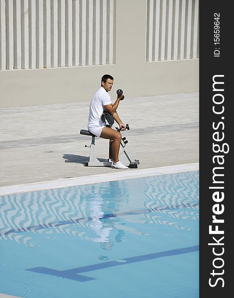 Young healthy athlete man exercise at poolside. Young healthy athlete man exercise at poolside