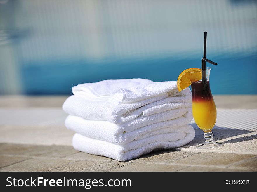 Coctail dring with orange att sunny day on swimming pool side with white towel decoraton. Coctail dring with orange att sunny day on swimming pool side with white towel decoraton