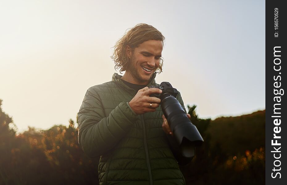 Portrait of a professional wildlife photographer smiling after checking photos on modern camera very happy. Portrait of a professional wildlife photographer smiling after checking photos on modern camera very happy