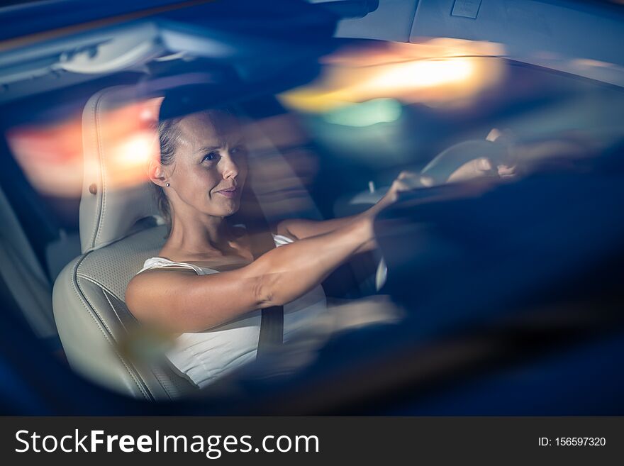 Young female driver driving her car at night