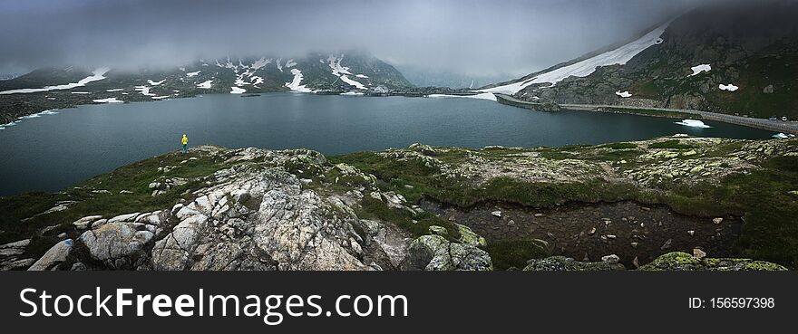 Young admiring the natural beauty of a glaciar lake in Swiss Alps - Panoramic image