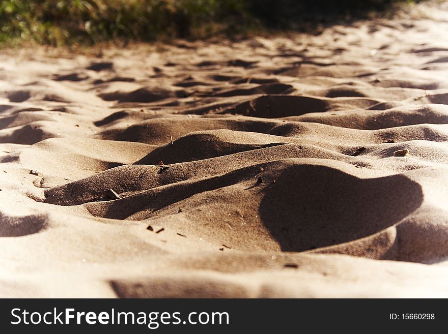 Sand and beautiful shades on it.Yellow sea sand. A beach sand.