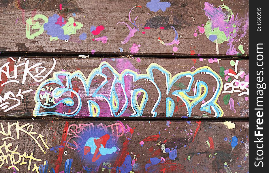 Close-up of picnic table decorated with colorful graffiti in paint. Close-up of picnic table decorated with colorful graffiti in paint