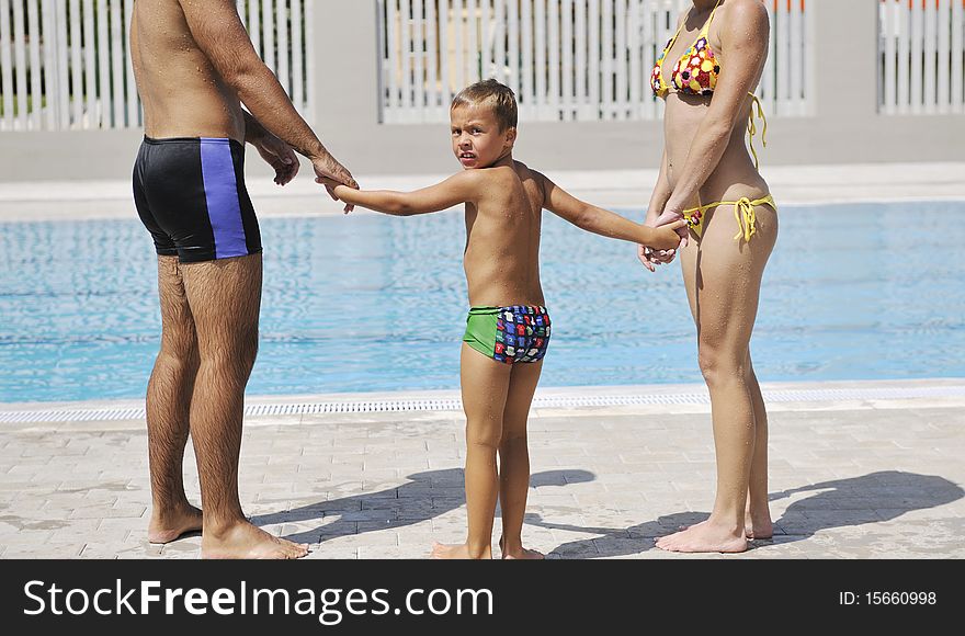 Happy Young Family Have Fun On Swimming Pool