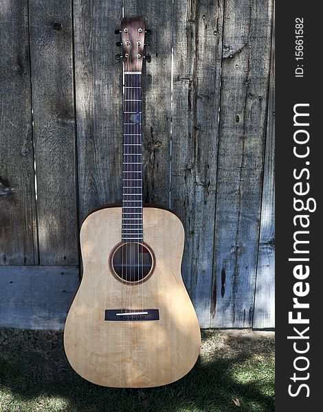 Traditional Guitar Against A Fence