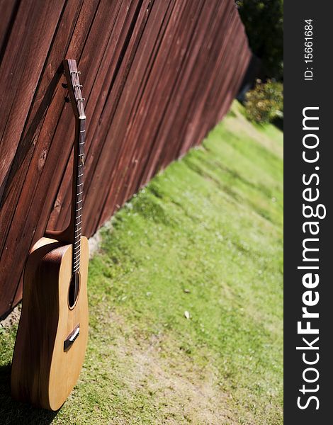 Guitar Against a Red Wood Fence