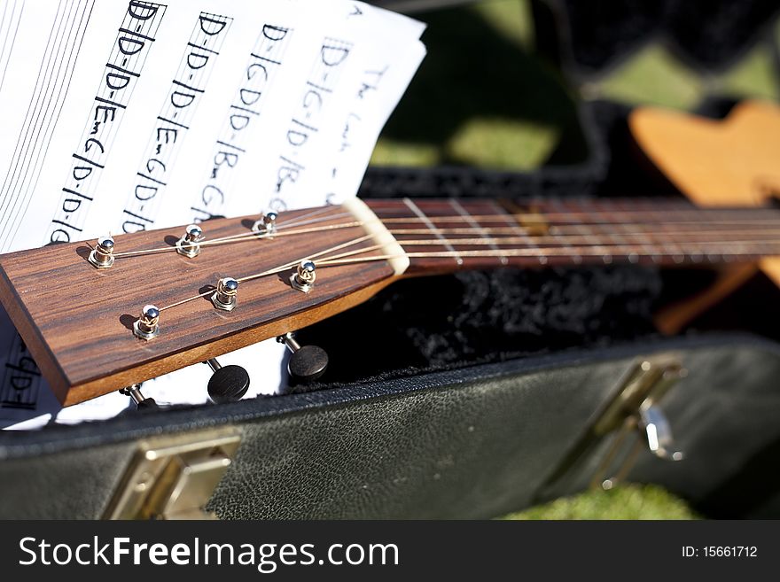 Fret board of guitar in case with tuning keys and a sheet of music. Fret board of guitar in case with tuning keys and a sheet of music.