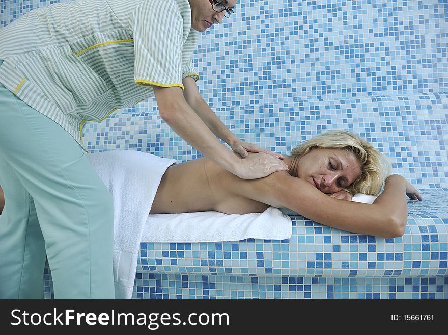 Hands massaging her back - A pretty woman getting a shoulder and back massage at spa and wellness center. Hands massaging her back - A pretty woman getting a shoulder and back massage at spa and wellness center