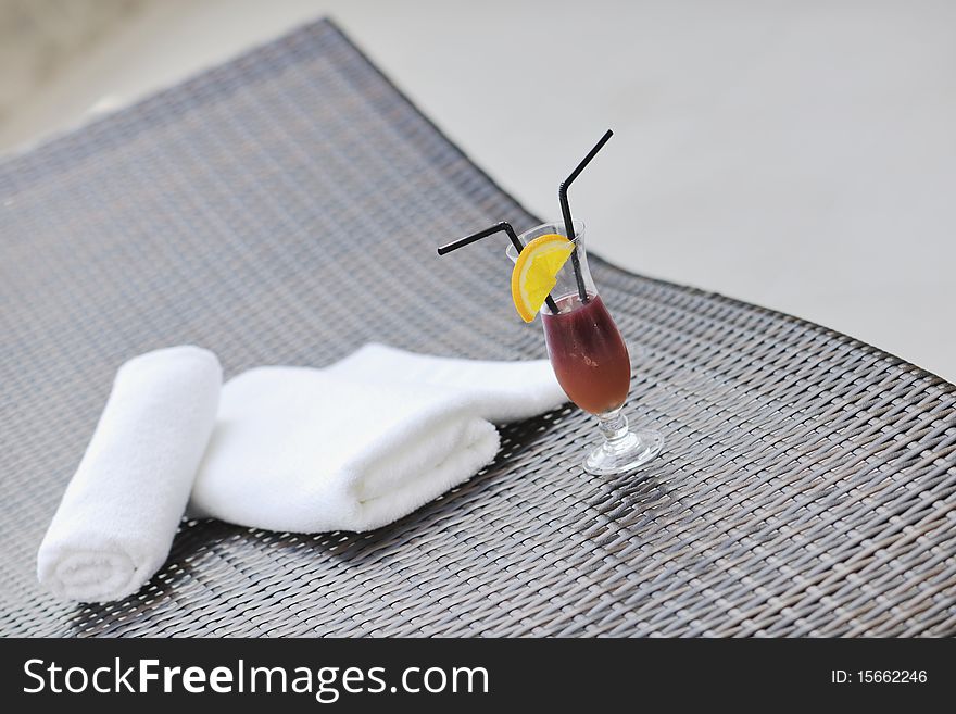 Coctail dring with orange att sunny day on swimming pool side with white towel decoraton. Coctail dring with orange att sunny day on swimming pool side with white towel decoraton