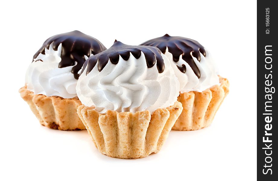 Muffins on a white background with cream and chocolate. Muffins on a white background with cream and chocolate
