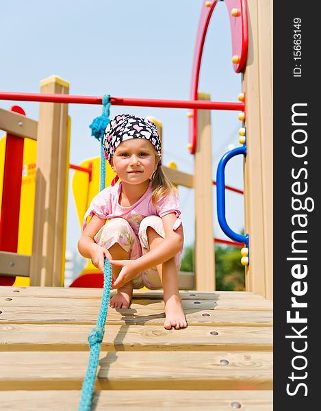 Pretty little girl on outdoor playground equipment. Pretty little girl on outdoor playground equipment