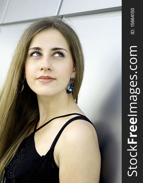 Beautiful fashionable young woman with flowing hair and large earrings with blue stone. Beautiful fashionable young woman with flowing hair and large earrings with blue stone