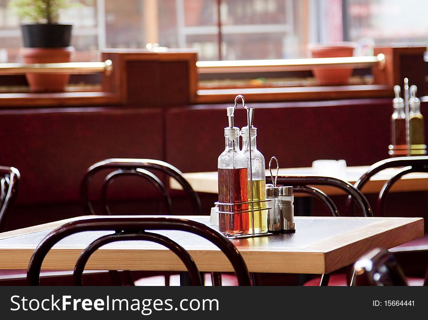 Two glass containers with vinegar and oil on restaurant table