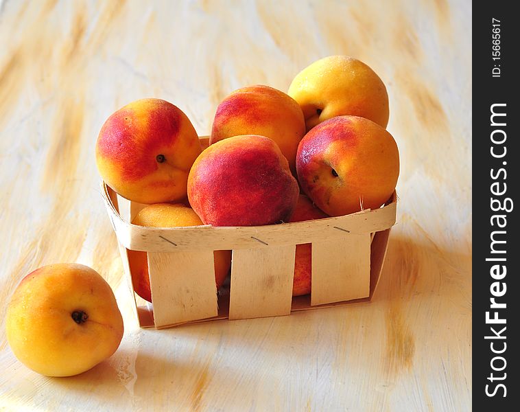 Peaches are in a small basket